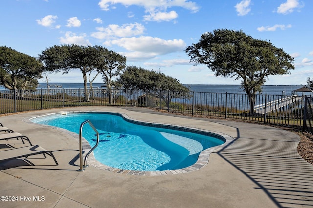 view of swimming pool featuring a patio area and a water view