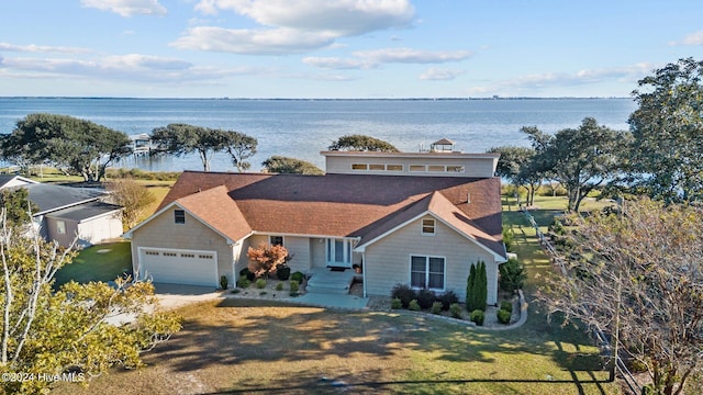 view of front of home featuring a water view, a front yard, and a garage