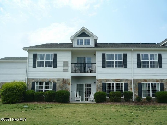 view of front facade with a front lawn and a balcony