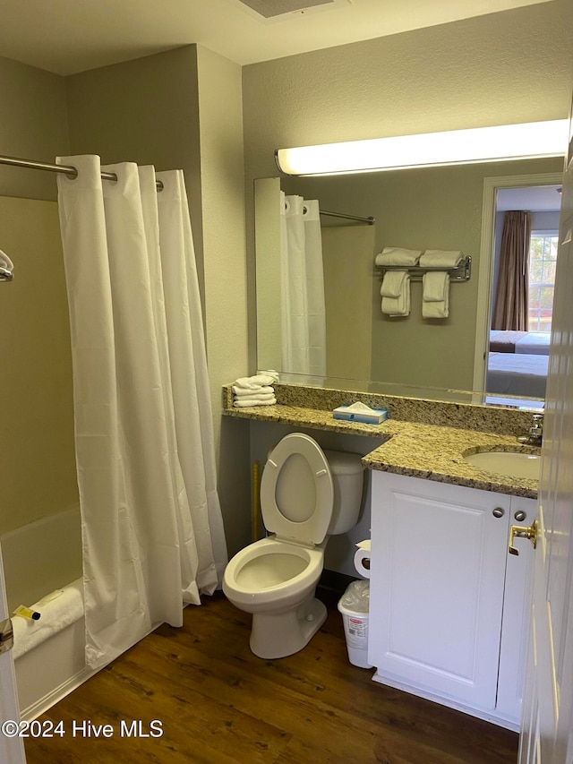 full bathroom featuring vanity, hardwood / wood-style floors, toilet, and shower / bathtub combination with curtain