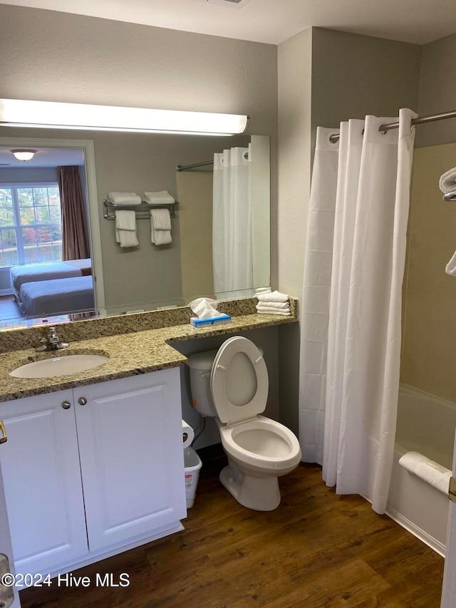 full bathroom featuring toilet, shower / bath combo, hardwood / wood-style flooring, and vanity