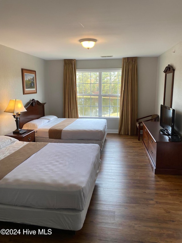 bedroom with dark hardwood / wood-style flooring