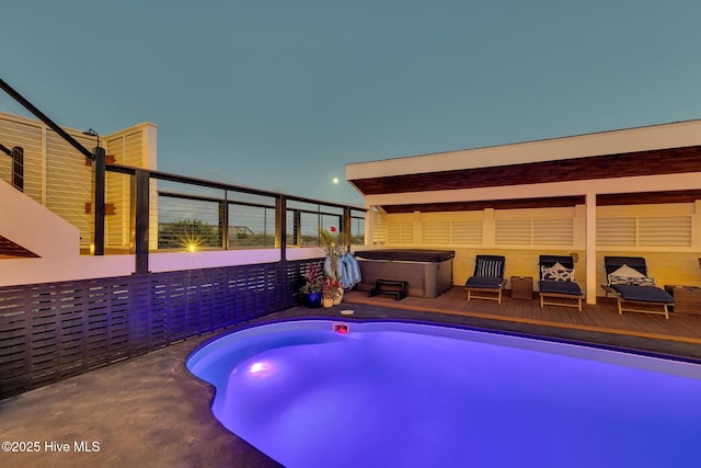 view of swimming pool featuring a hot tub