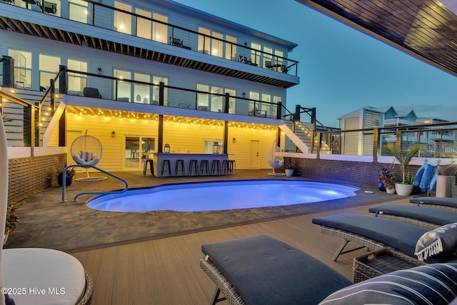 view of pool featuring outdoor dry bar, stairway, a fenced in pool, and a patio