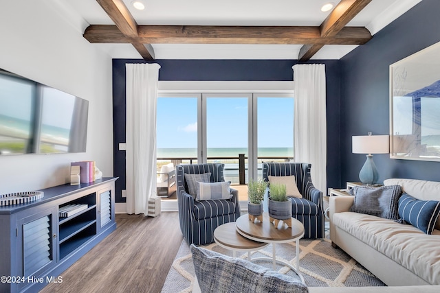 living area featuring beamed ceiling, a water view, coffered ceiling, and wood finished floors