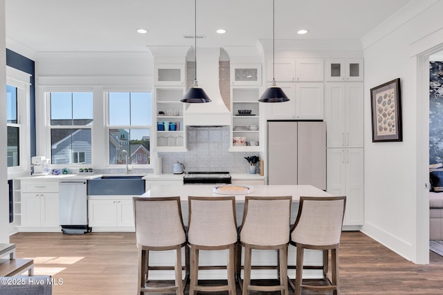 kitchen with crown molding, premium range hood, dishwasher, freestanding refrigerator, and stove