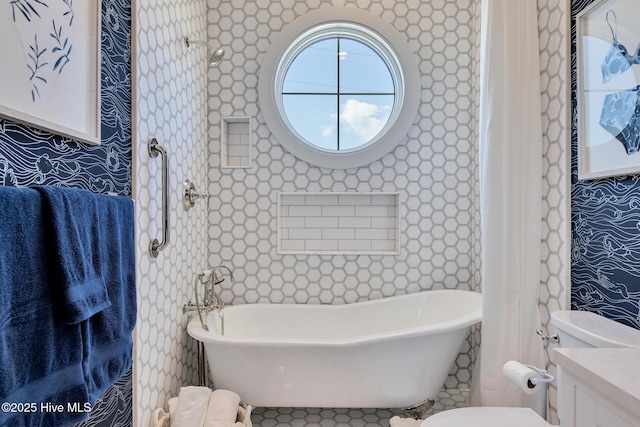 full bathroom featuring a soaking tub, toilet, and vanity