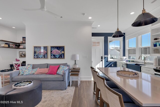 living area with baseboards, ornamental molding, recessed lighting, dark wood-style floors, and a ceiling fan