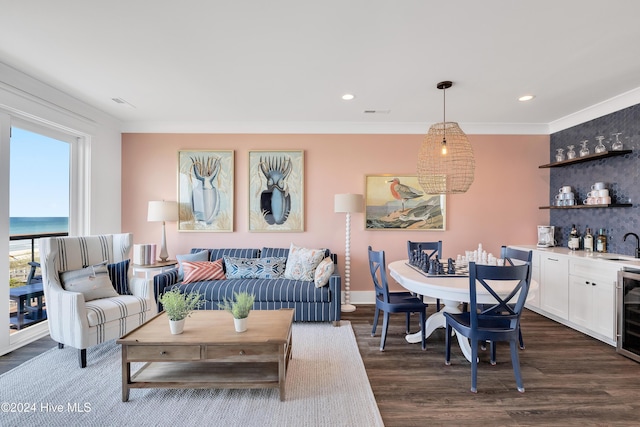 living area featuring dark wood finished floors, recessed lighting, wine cooler, crown molding, and indoor wet bar