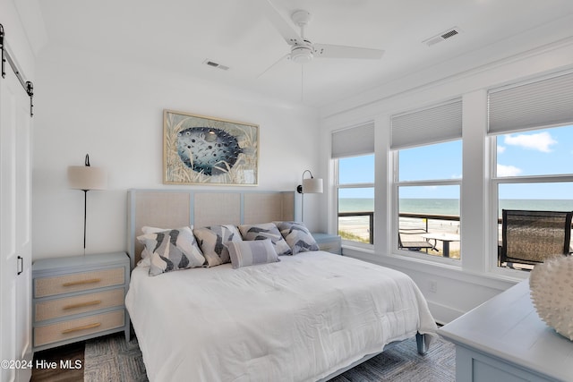 bedroom featuring visible vents, multiple windows, and a barn door