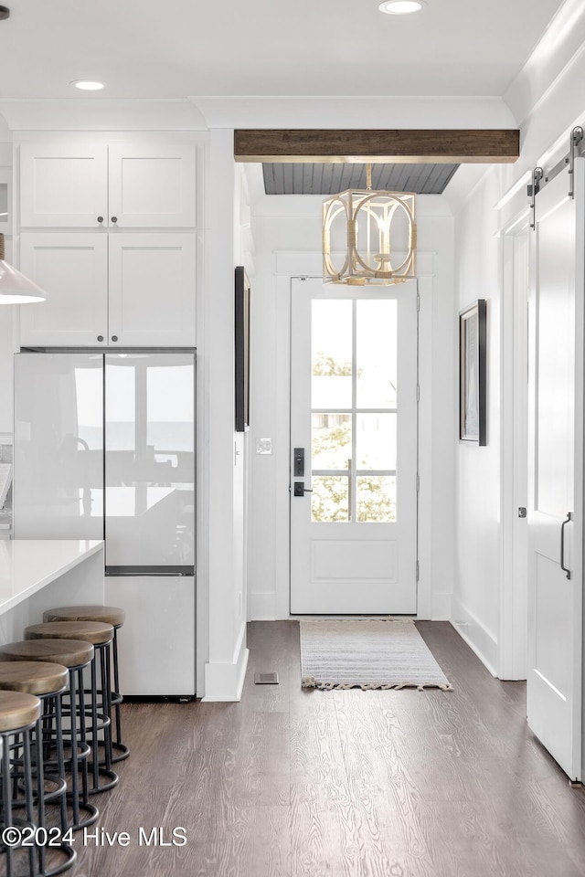 doorway to outside featuring an inviting chandelier, beamed ceiling, baseboards, and dark wood-style flooring