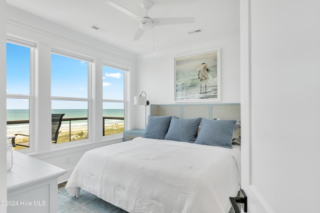 bedroom with visible vents, ceiling fan, and a water view