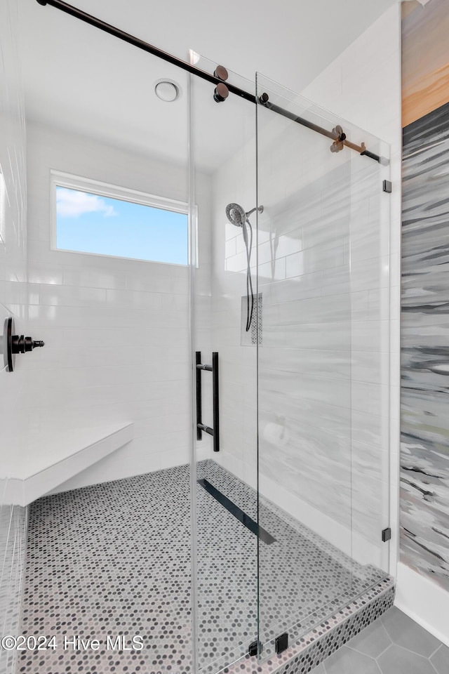 full bath with tile patterned flooring and a shower stall