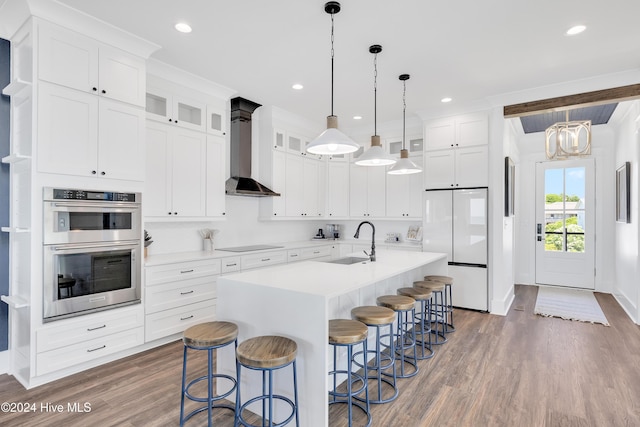 kitchen with a sink, double oven, black electric stovetop, wall chimney exhaust hood, and white refrigerator