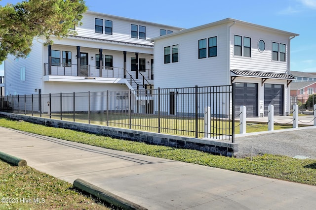 view of front of house featuring a fenced front yard, a front lawn, an attached garage, and a standing seam roof