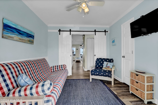 living room with dark hardwood / wood-style flooring, ornamental molding, a barn door, and ceiling fan