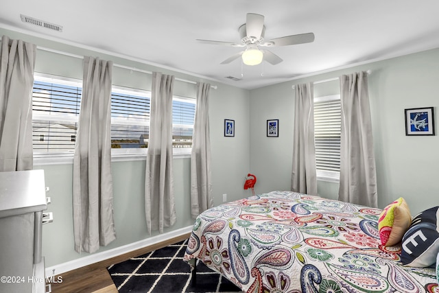 bedroom with dark hardwood / wood-style floors and ceiling fan