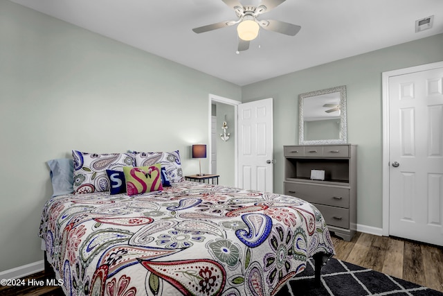 bedroom with dark hardwood / wood-style floors and ceiling fan