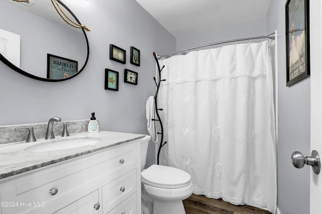 bathroom with vanity, curtained shower, wood-type flooring, and toilet