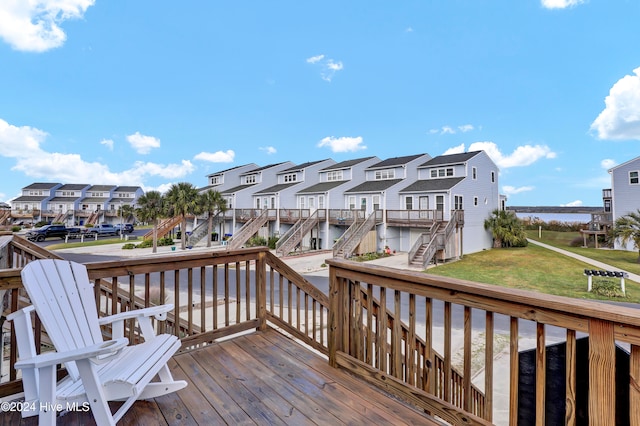 wooden deck featuring a lawn