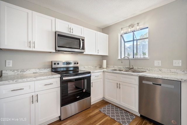 kitchen with sink, appliances with stainless steel finishes, and white cabinetry