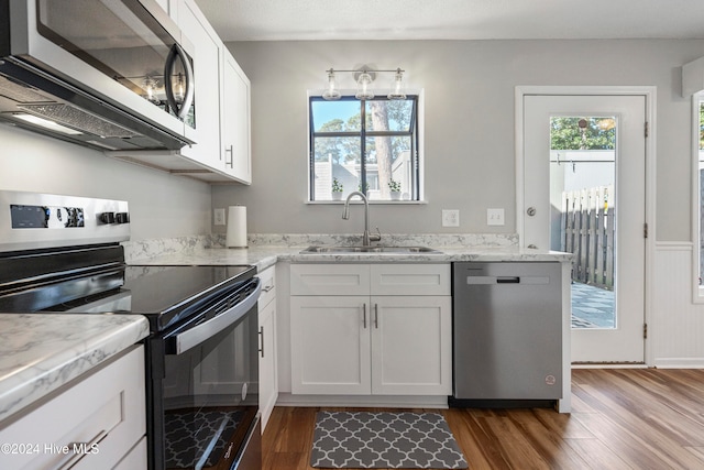 kitchen with sink, white cabinets, stainless steel appliances, and dark hardwood / wood-style floors