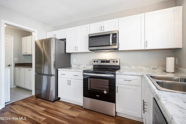 kitchen featuring white cabinetry, stainless steel appliances, and dark hardwood / wood-style flooring