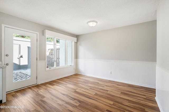 empty room featuring a textured ceiling and light hardwood / wood-style floors