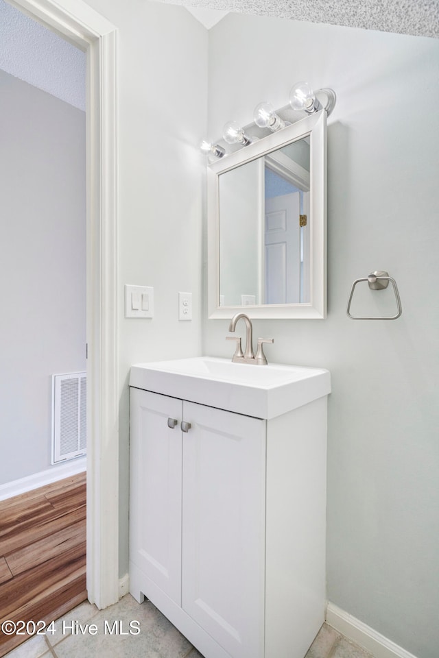 bathroom with vanity, hardwood / wood-style floors, and a textured ceiling