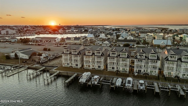 aerial view at dusk featuring a water view