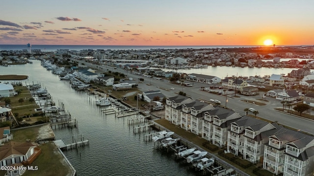 aerial view at dusk featuring a water view