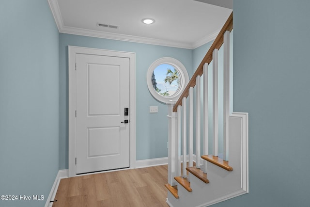 foyer entrance featuring ornamental molding and light wood-type flooring