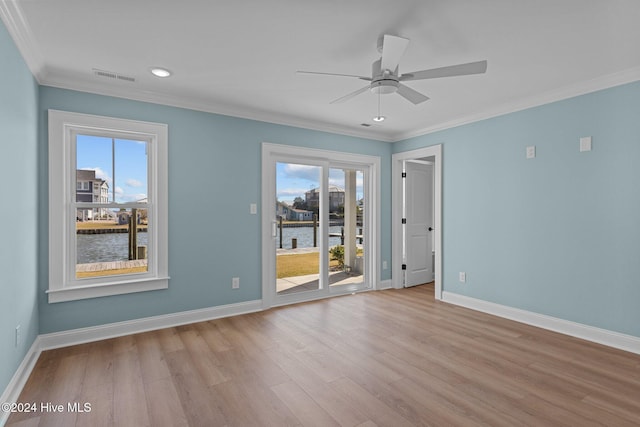 unfurnished room with light wood-type flooring, a water view, plenty of natural light, and ornamental molding