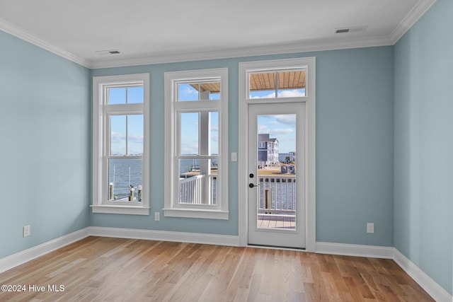 doorway featuring crown molding, light hardwood / wood-style flooring, and a water view