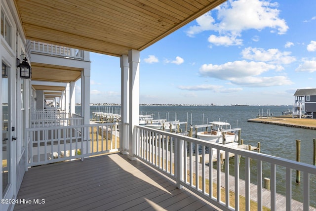 wooden deck with a boat dock and a water view