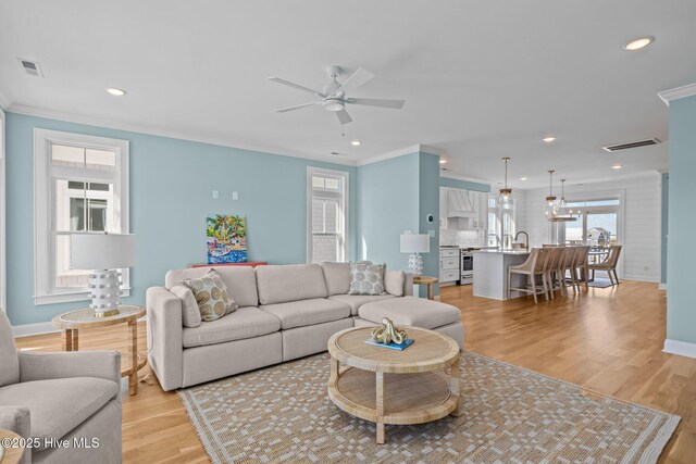 empty room featuring light hardwood / wood-style flooring, ceiling fan, and ornamental molding