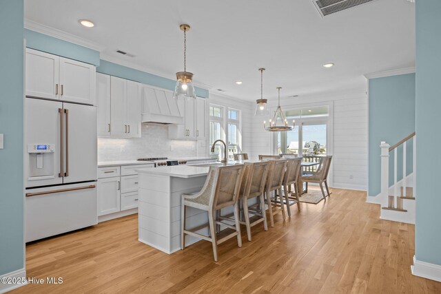 unfurnished living room featuring ceiling fan, sink, light hardwood / wood-style floors, and ornamental molding