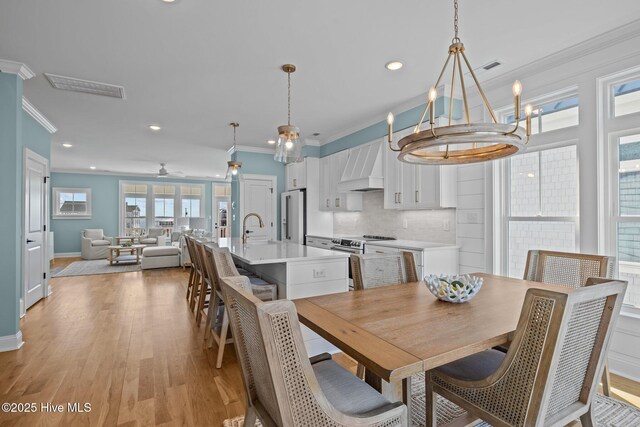 kitchen with hardwood / wood-style flooring, high end fridge, white cabinetry, and sink