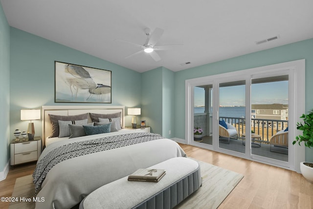 bedroom with ceiling fan, access to exterior, a water view, and light hardwood / wood-style flooring