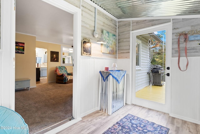 doorway with vaulted ceiling and hardwood / wood-style flooring