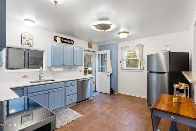 kitchen with tasteful backsplash, dark hardwood / wood-style floors, sink, blue cabinetry, and stainless steel appliances