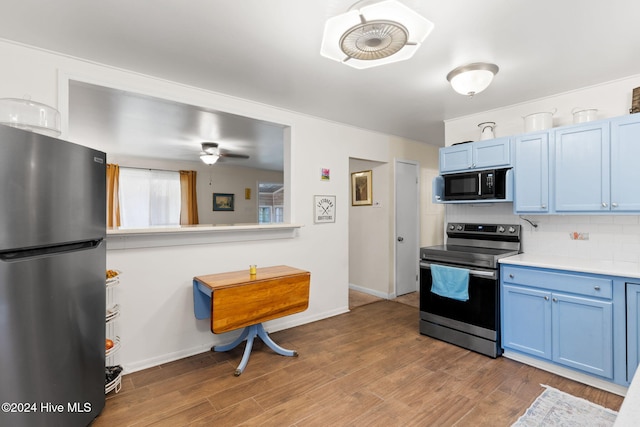 kitchen with ceiling fan, backsplash, hardwood / wood-style flooring, stainless steel appliances, and blue cabinets