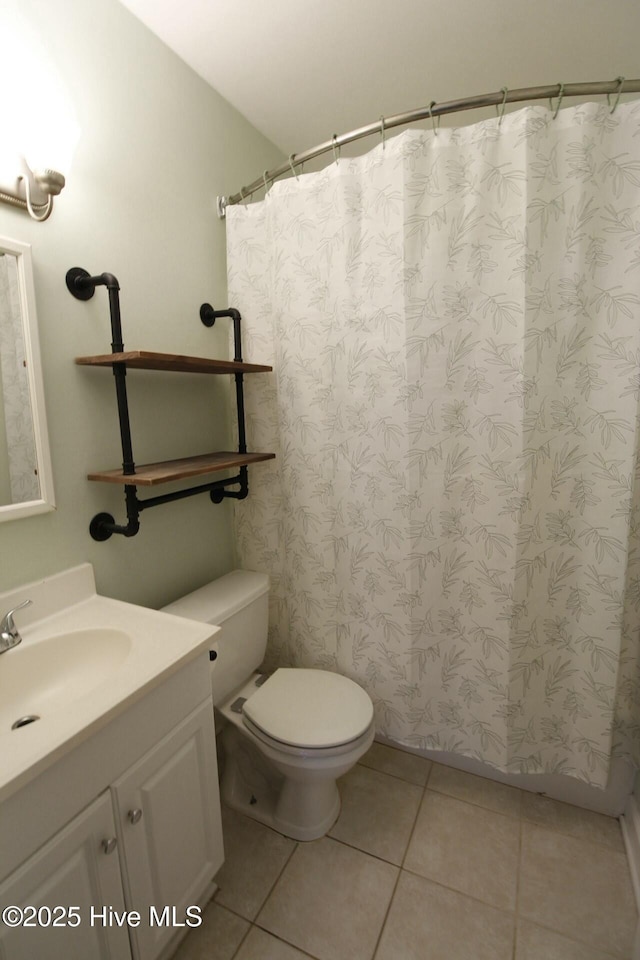 bathroom with tile patterned flooring, vanity, and toilet