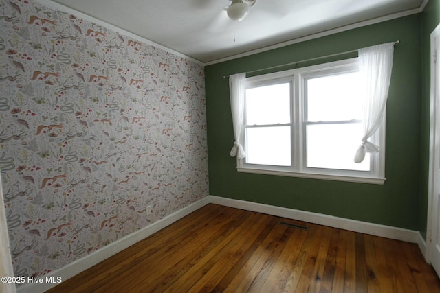 spare room with hardwood / wood-style floors, a healthy amount of sunlight, and crown molding