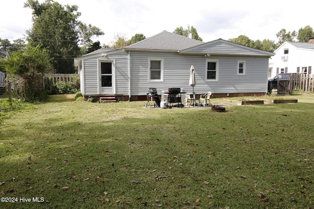 rear view of house featuring a yard