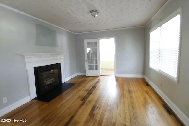 unfurnished living room featuring hardwood / wood-style floors and crown molding