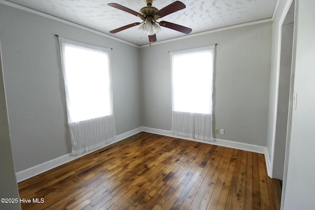 empty room featuring dark wood-type flooring, ceiling fan, and ornamental molding