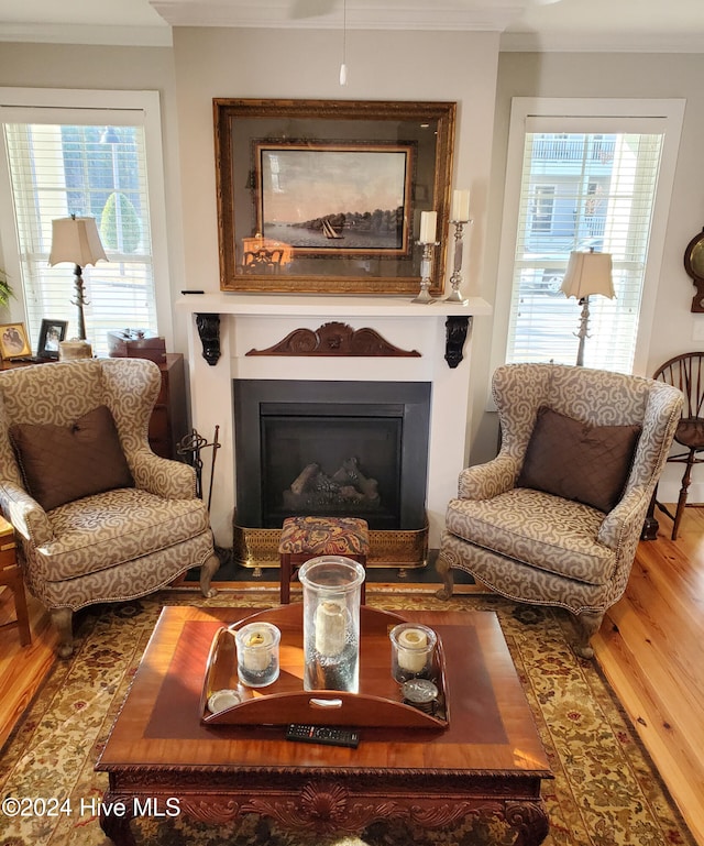 living area with crown molding and hardwood / wood-style flooring