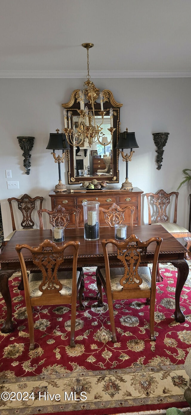 dining space with crown molding and a chandelier