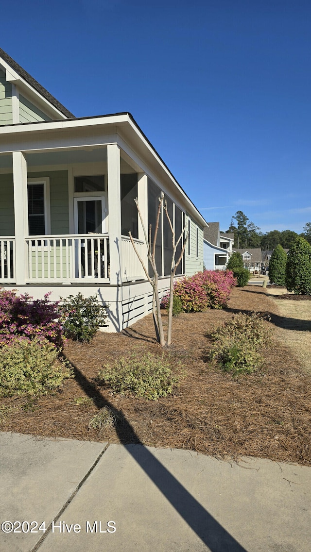 view of side of home with covered porch